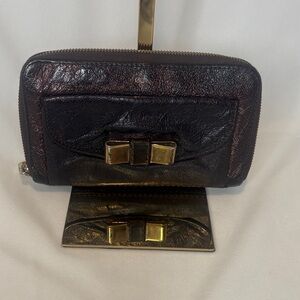 Chloe Lilly bow front long wallet in a metallic maroon brown